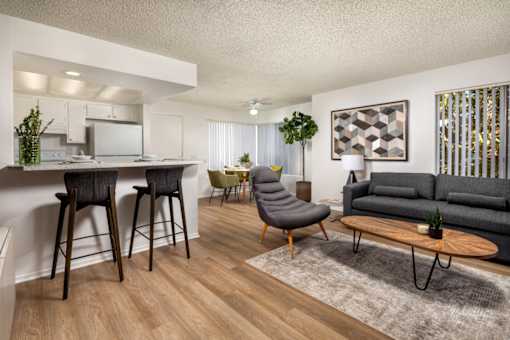 A modern living room with a grey sofa and wooden floors.