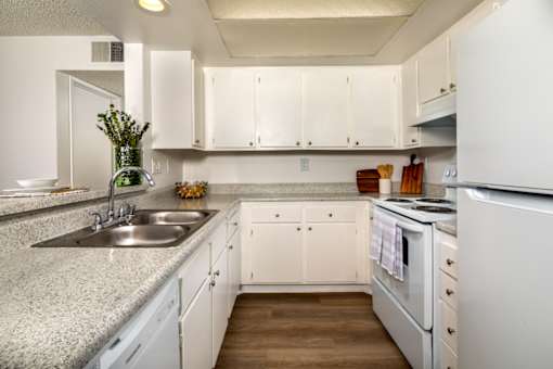 A kitchen with white cabinets and appliances.