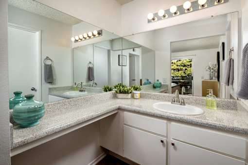 A bathroom with a sink, mirror, and lights.