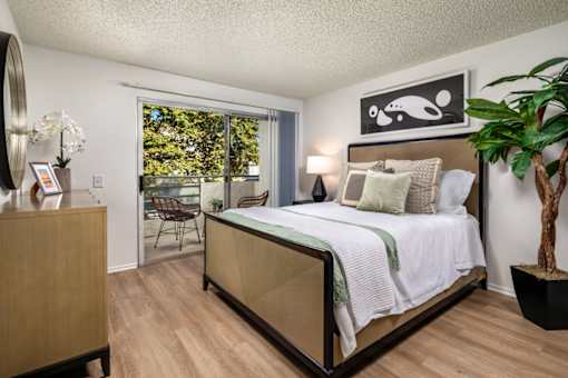 A bedroom with a large bed and a wooden dresser.