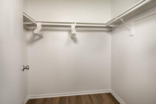 A white closet with a door and a shelf above it.