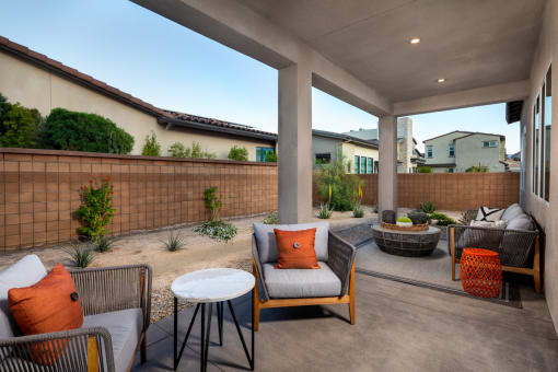a covered patio with chairs and tables and a fire pit