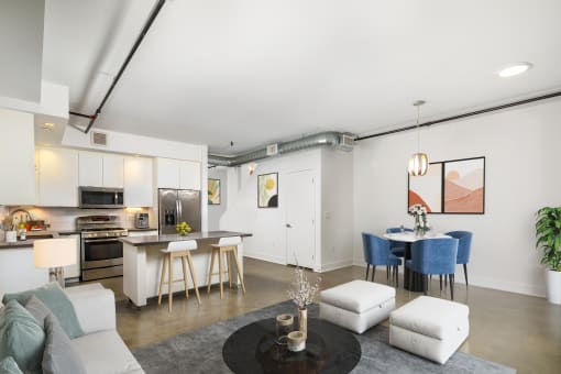 a living room with white walls and a kitchen with a breakfast bar and a dining table  at The LC, Los Angeles, California