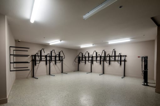 a workout room with weights on racks in the corner of a room