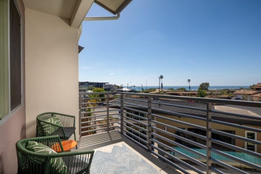 a balcony with chairs and a view of the ocean