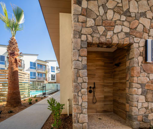 the entrance to a building with a shower and a palm tree