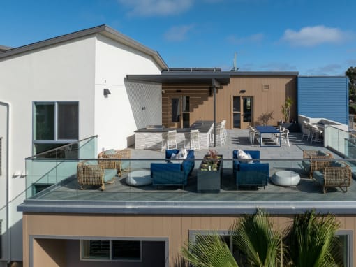 a roof terrace with furniture on top of a house