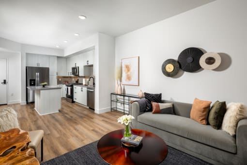 a living area with a couch coffee table and a kitchen in the background at VORA LUX, San Diego, CA 92120