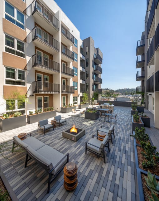 an outdoor patio with a firepit and lounge chairs at VORA LUX, San Diego
