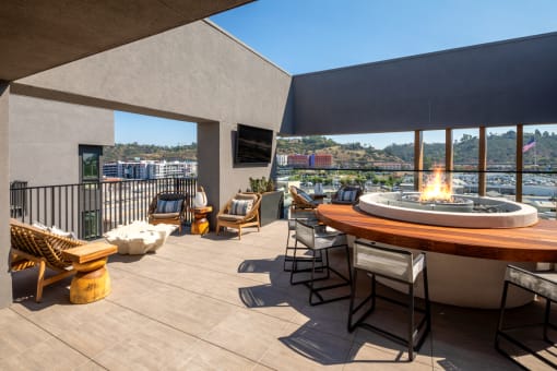 a rooftop deck with a fire pit and a view of the city at VORA LUX, San Diego, CA