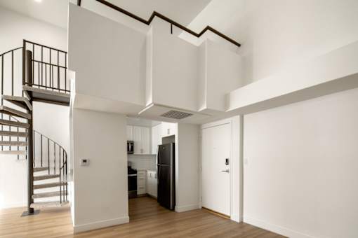 A black and white kitchen with a staircase on the left.