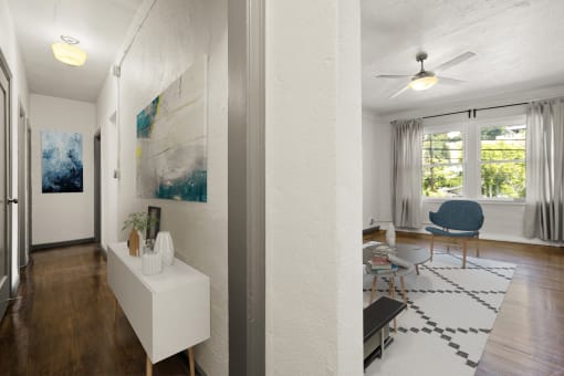 a living room with hardwood floors and white walls at Del Mor Apartments, Los Angeles, California