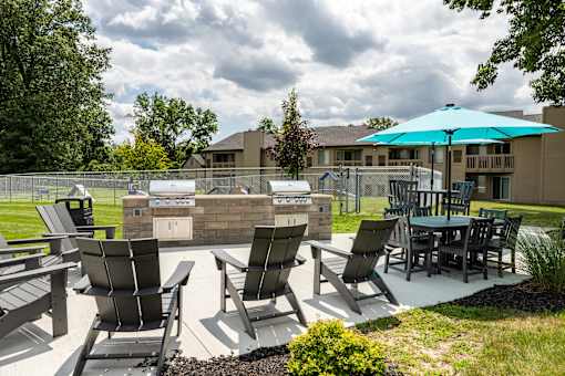 our apartments have an outdoor patio with a grill and table