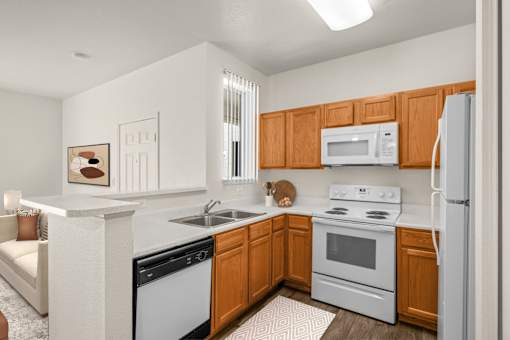 A kitchen with white appliances and wooden cabinets.