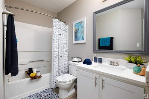 A bathroom with a toilet, sink, and shower.