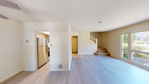 A spacious, empty room with a staircase leading to the second floor.