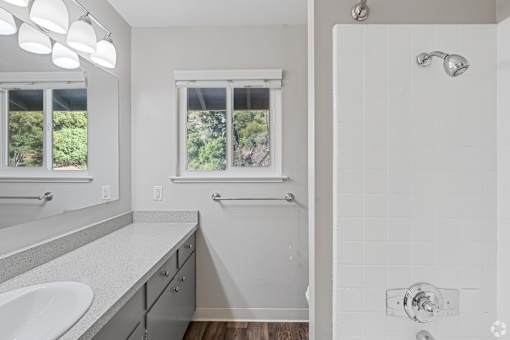 A white bathroom with a window and a sink.