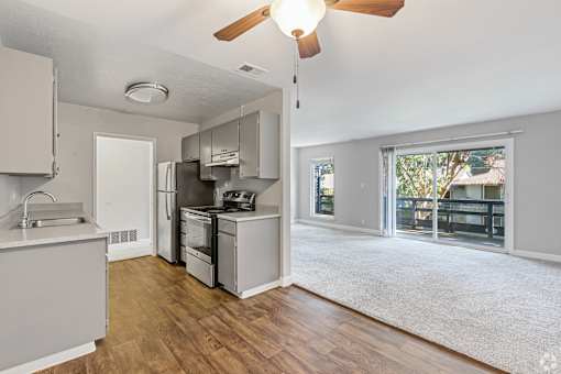 A kitchen with a refrigerator, sink, and cabinets.