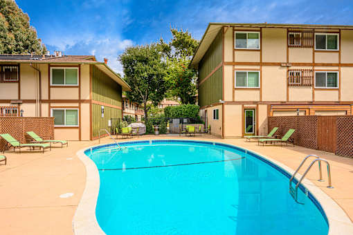 A swimming pool in front of apartment buildings.