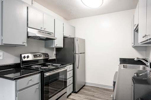 A kitchen with a stove, oven, and refrigerator.