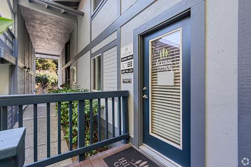 A balcony with a railing and a door with a window.