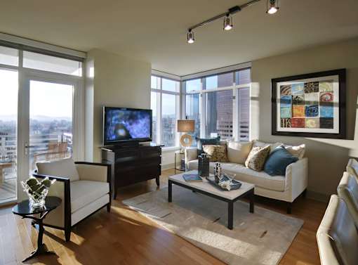 A living room with a white couch, a coffee table, and a television.