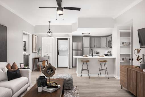 A modern kitchen with white appliances and a dining area with a white couch and a coffee table.