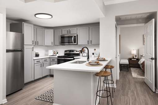 A modern kitchen with a white island and stools.