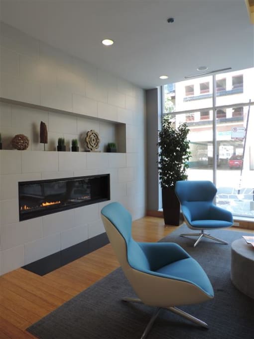 a living room with a fireplace and two blue chairs
