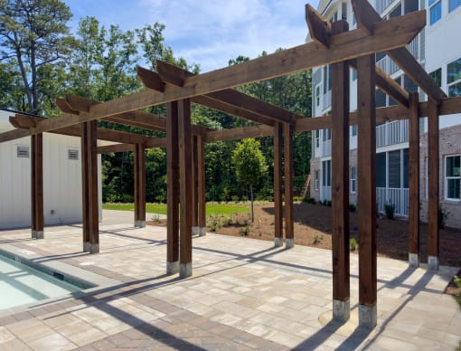 Pergola on the pool deck next to apartment building