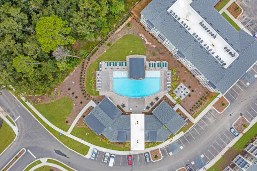 an overhead view of a building with a swimming pool