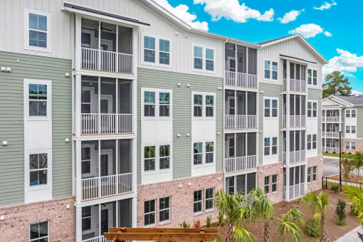 an exterior view of an apartment building with a brick wall and balconies