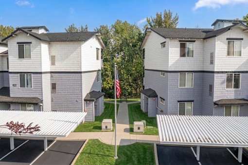 Apartment complex with a flag on a pole in the front yard.