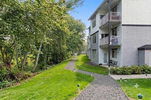 A residential building with a balcony and a small garden.