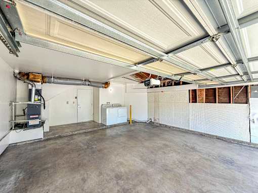 An attached two car garage with a full size washer and dryer.