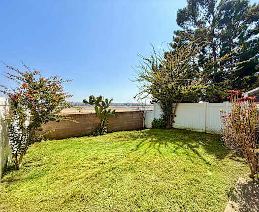 A fenced backyard with a lush green lawn.