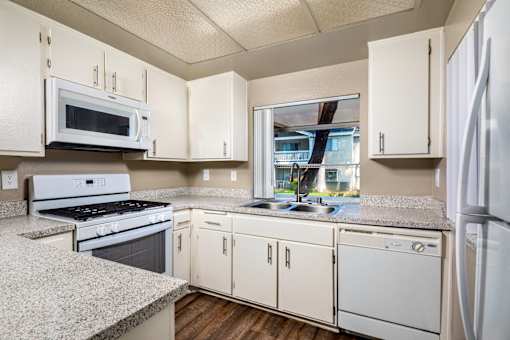 A kitchen with white appliances and cabinets.