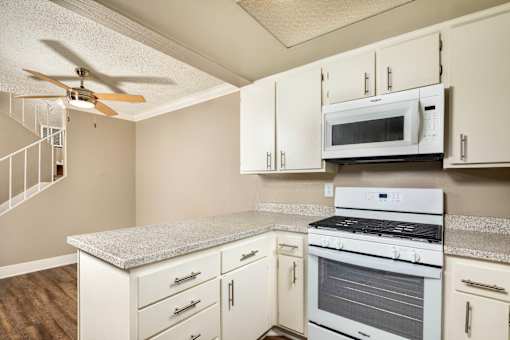 A kitchen with a gas stove, microwave, and oven.