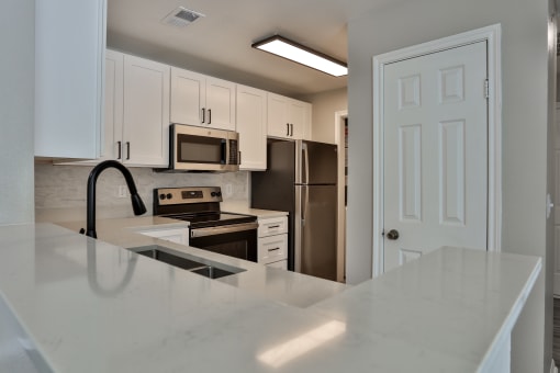 a kitchen with white cabinets and stainless steel appliances at The Quarry Alamo Heights, San Antonio, TX, 78209