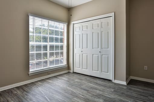 an empty bedroom with a large window at The Quarry Alamo Heights, San Antonio, TX