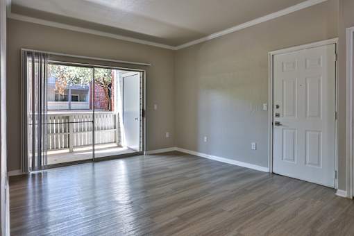 A room with a sliding glass door leading to a balcony.