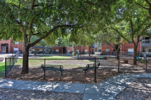 a park with benches and trees in front of a building at The Quarry Alamo Heights, San Antonio, Texas