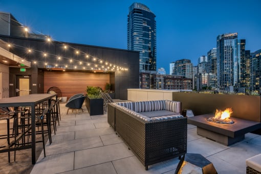a rooftop patio with a city skyline at night
