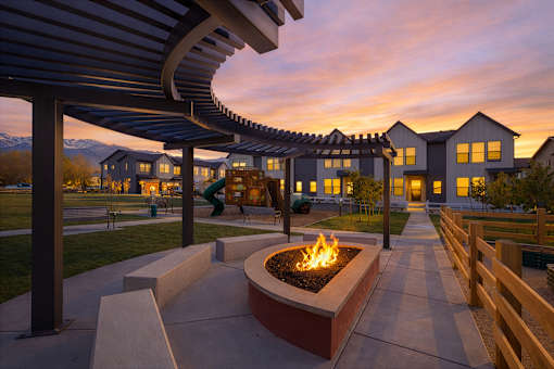 A fire pit sits in the middle of a walkway under a canopy.