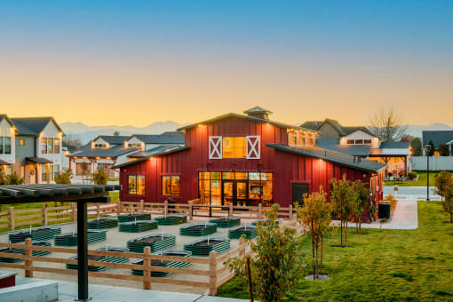 a red barn with an outdoor amphitheater at sunset