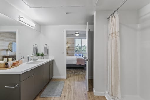 Bathroom with a shower and a bed in the background at Array La Mesa, La Mesa, CA