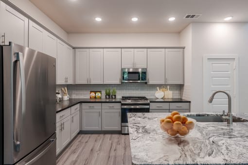 a kitchen with stainless steel appliances and marble counter tops