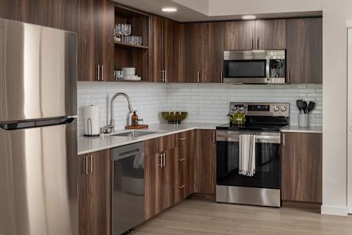 A modern kitchen with wooden cabinets and stainless steel appliances.