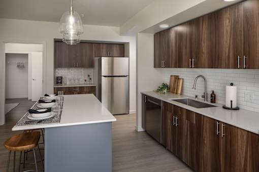 A modern kitchen with a white island and wooden cabinets.