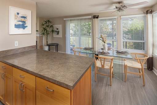 a kitchen and dining room with a glass table and chairs